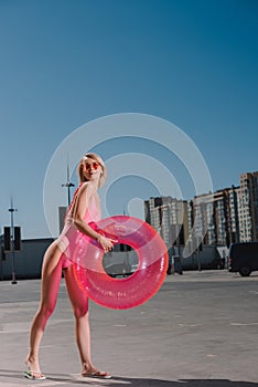 happy young woman in swimsuit with inflatable ring