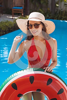 happy young woman in swimsuit with inflatable ring
