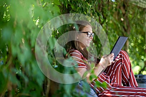 Young woman with tablet computer in the park photo