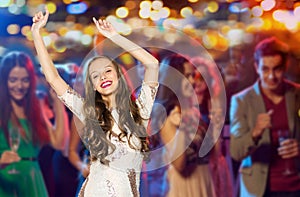 Happy young woman or teen dancing at disco club