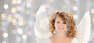 Happy young woman or teen girl with angel wings