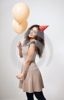 Happy young woman or teen girl in brown dress with helium air balloons