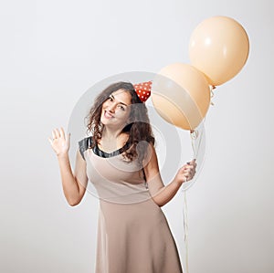 Happy young woman or teen girl in brown dress with helium air balloons