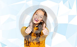 Happy young woman or teen girl showing thumbs up