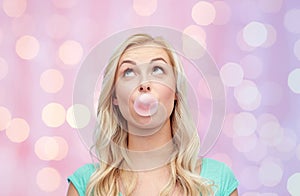 Happy young woman or teenage girl chewing gum