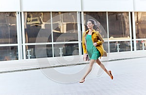 Happy young woman or teenage girl on city street