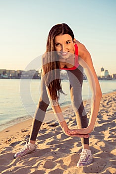 Happy young woman tiping on the beach to be flexible