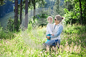 Happy young woman and toddler son on sunny meadow