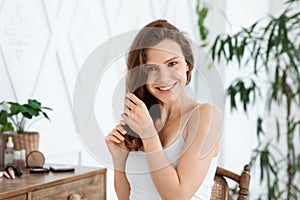 Happy young woman touching her silky hair