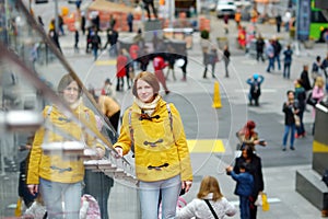 Happy young woman tourist sightseeing at Times Square in New York City. Female traveler enjoying view of downtown Manhattan.