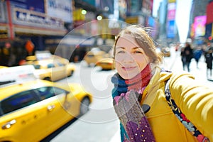 Happy young woman tourist sightseeing at Times Square in New York City. Female traveler enjoying view of downtown Manhattan. photo