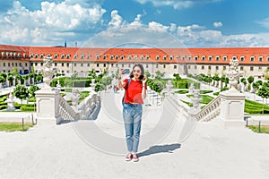 Mladá žena turistické procházky a obdivovat pohled na typické, ale nádherné květinové zahrady v barokním stylu v Evropě na slunné