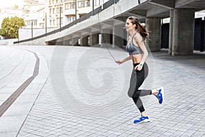 Happy young woman training with jumping-rope