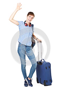 Happy young woman with travel bags waving her hand hello