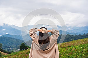 Happy young woman traveler relaxing and looking at the beautiful landscape in the morning