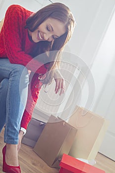 Happy young woman trying on footwear in store