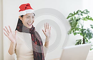 Happy young woman using laptop in  video call and celebrating christmas hoilday