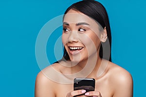 Happy young woman using mobile phone