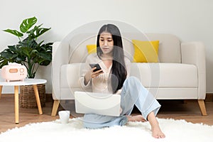 Happy young woman using smart phone for shopping online at home.