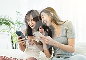 Happy young woman using their smart phones  sitting on a sofa  at home