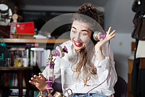 Happy young woman using a vintage phone