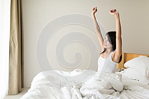 Happy young woman waking up at morning