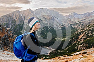 Happy young woman is walking along mountain trails in the Slovak High Tatras in the fall.