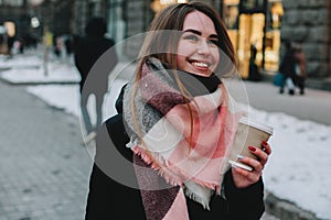 Happy young woman walking on city street during winter