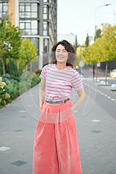 Happy young woman walking confident girl walks outdoors in street smiling