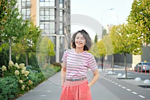 Happy young woman walking confident girl walks outdoors in street smiling