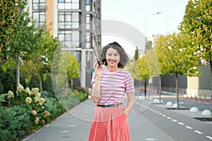 Happy young woman walking confident girl walks outdoors in street smiling