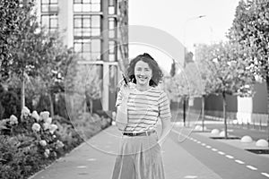 Happy young woman walking confident girl walks outdoors in street smiling