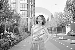 Happy young woman walking confident girl walks outdoors in street smiling