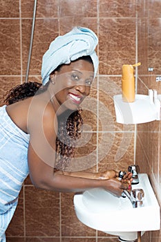Happy young woman washes her face