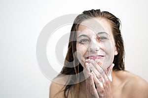 Happy Young Woman Washing her Face with Cream
