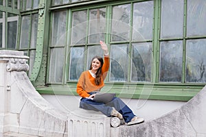 happy young woman waving hand while