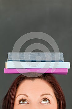 Happy young woman wearing books on her head