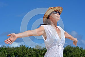 Happy young woman wearing brown sunhat enjoys the view and the w photo