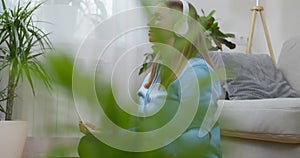 A happy young woman wearing headphones practicing yoga and meditation at home