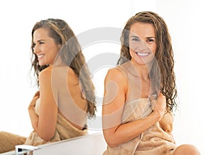 Happy young woman with wet long hair in bathroom