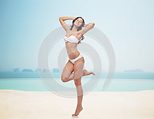 Happy young woman in white bikini swimsuit