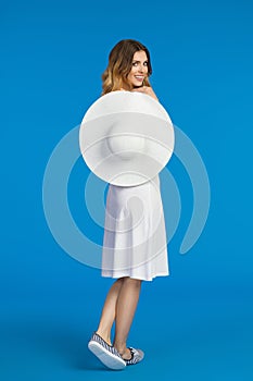 Happy Young Woman In White Dress Is Holding Sun Hat And Looking Over Shoulder