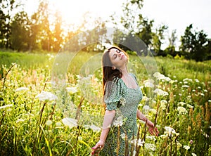 Happy young woman among wildflowers