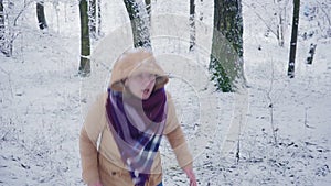 Happy young woman in winter forest. Jump and dance