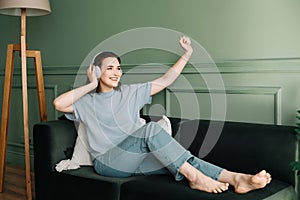 Happy young woman in wireless headphones listening to music while dancing. Rhythmic Euphoria. Joyful Woman Grooving to