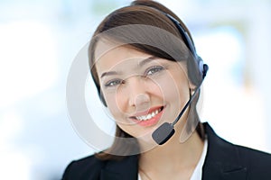 Happy young woman working at callcenter, using headset