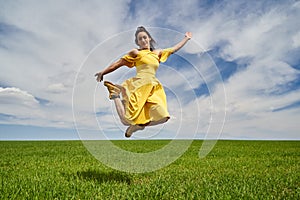 Happy young woman jumping for joy on a wheat field