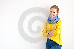Happy young woman in yellow sweater on white background photo