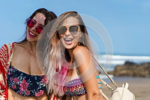 happy young women in bikini and sunglasses together