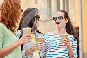 Happy young women drinking coffee on city street